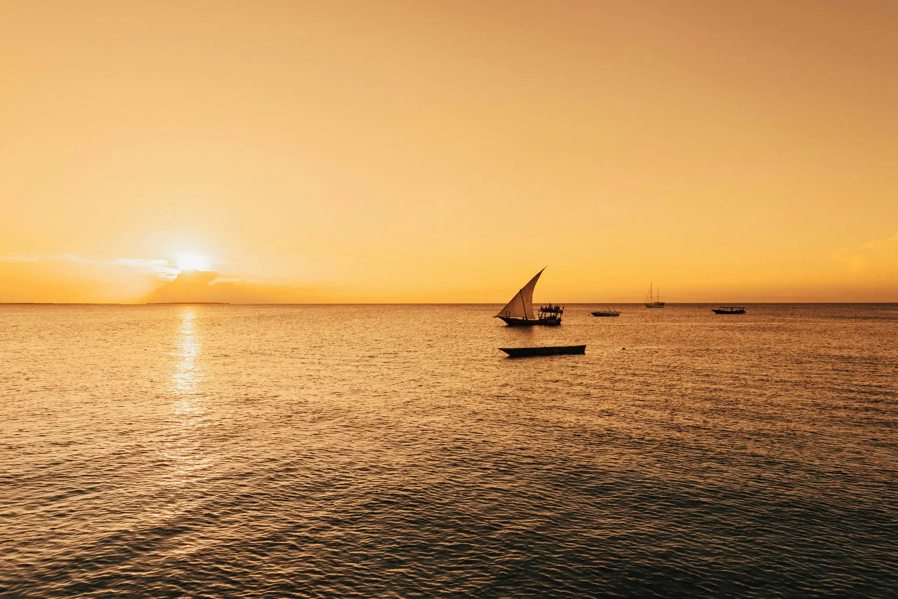 A dhow boat silhouetted against a Zanzibar sunset